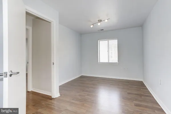 an empty room with wooden floor and windows
