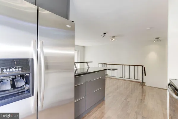 a hallway with kitchen island a large window and stainless steel appliances