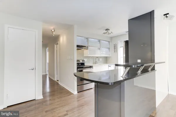 a kitchen with kitchen island a sink and wooden floor