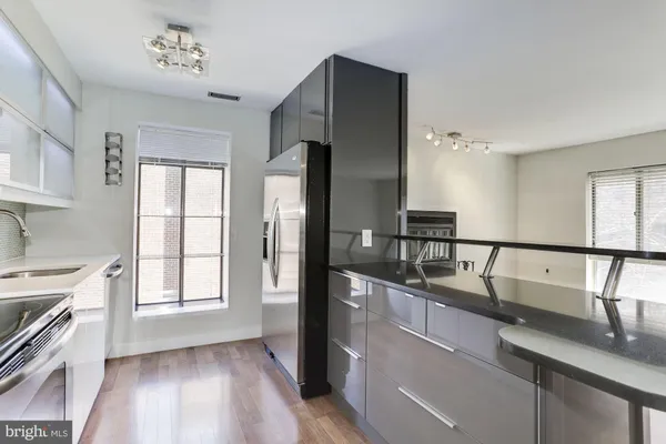 a kitchen with stainless steel appliances granite countertop a sink a stove and refrigerator