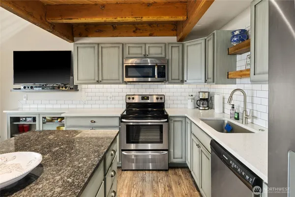 a kitchen with stainless steel appliances granite countertop a sink stove microwave and cabinets