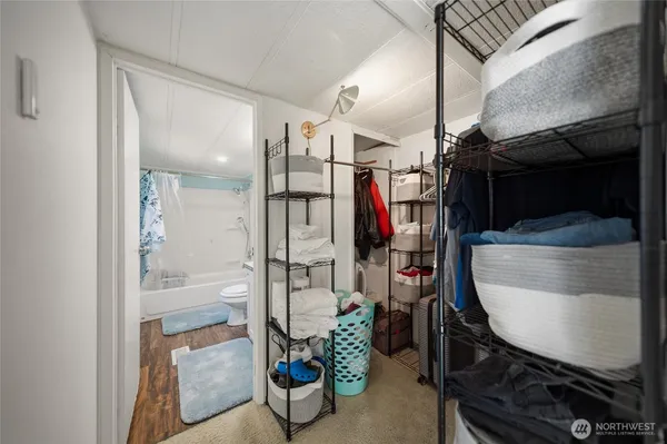 a view of walk in closet with clothes and shoes