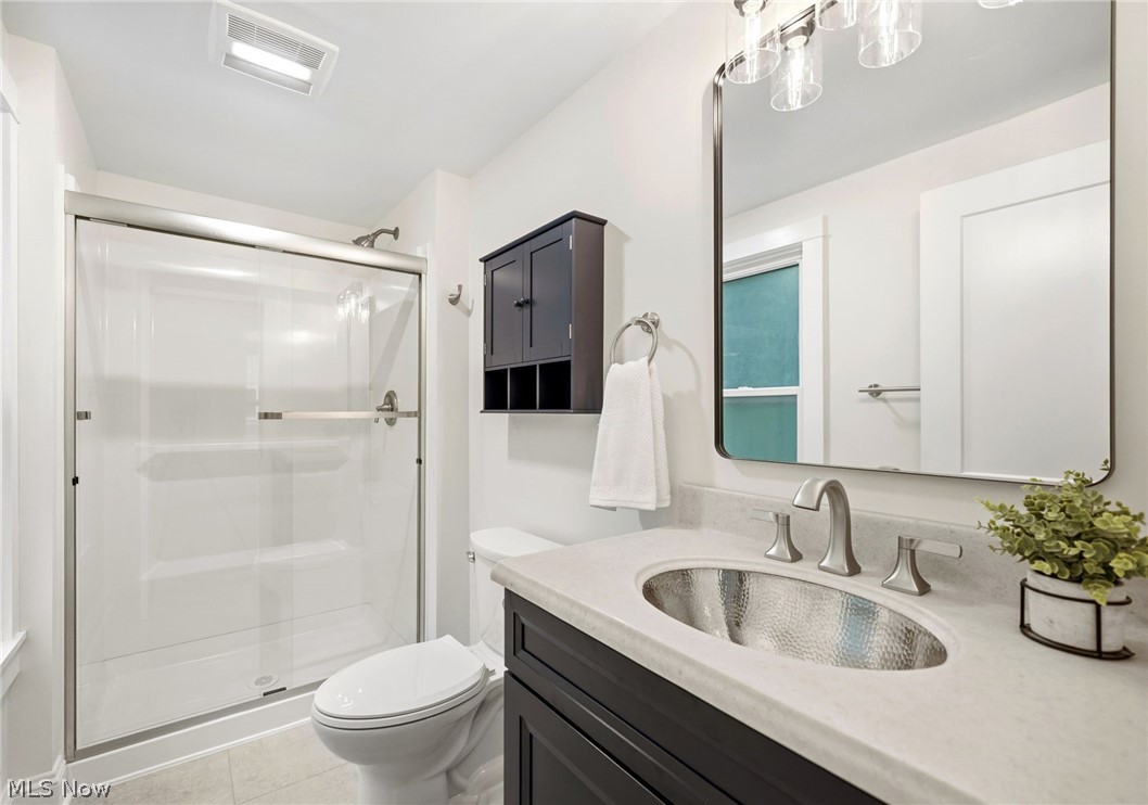 272 Miles Road Chagrin Falls, OH 44022 - Photo 20 of 36 Owner suite bathroom featuring a vanity with a hammered metal vessel sink, light countertop, and dark cabinetry