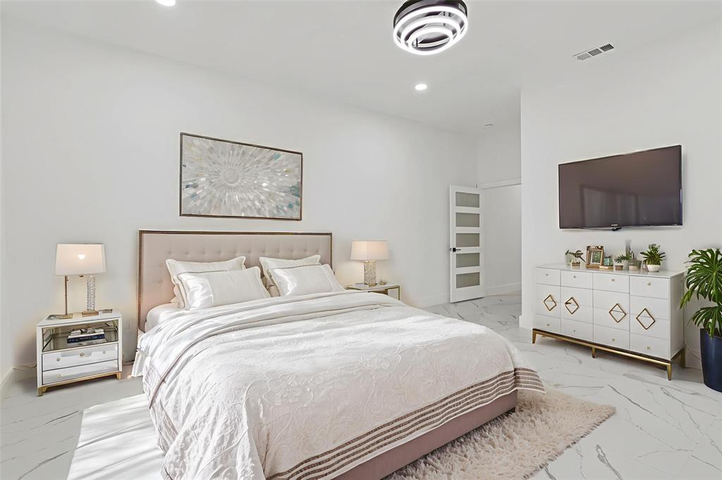 9726 Sunset Drive Frisco, TX 75033 - Photo 5 of 12 a bedroom with a bed and a flat tv screen on dresser