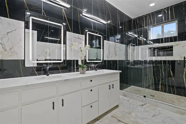 a bathroom with a double vanity sink a mirror and shower