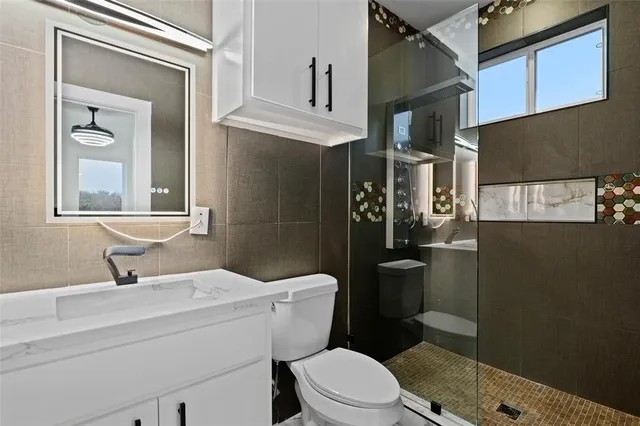 a bathroom with a toilet a sink and mirror