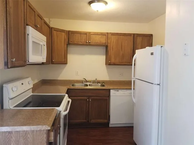 a kitchen with a refrigerator sink and cabinets