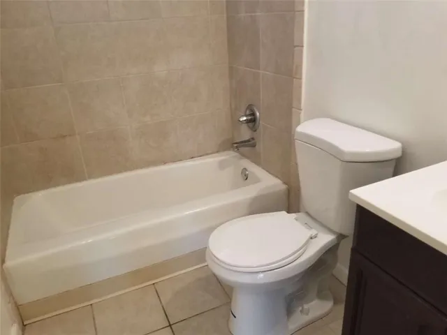 a white toilet sitting next to a bath tub