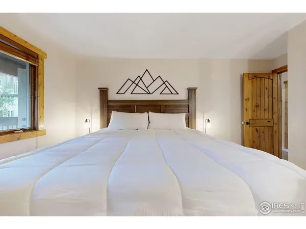 a bedroom with a bed and a painting on the wall