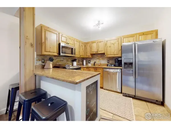 a kitchen with kitchen island granite countertop a sink cabinets and stainless steel appliances