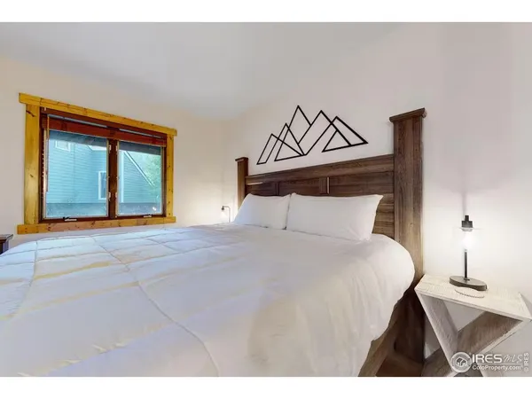 a bedroom with a bed and a painting on the wall