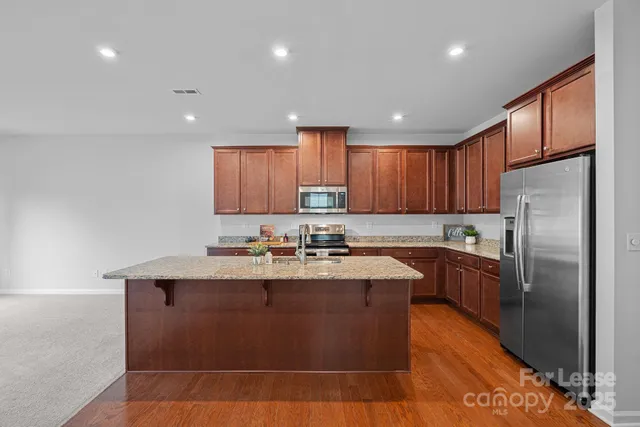 a kitchen with granite countertop a sink stainless steel appliances and cabinets