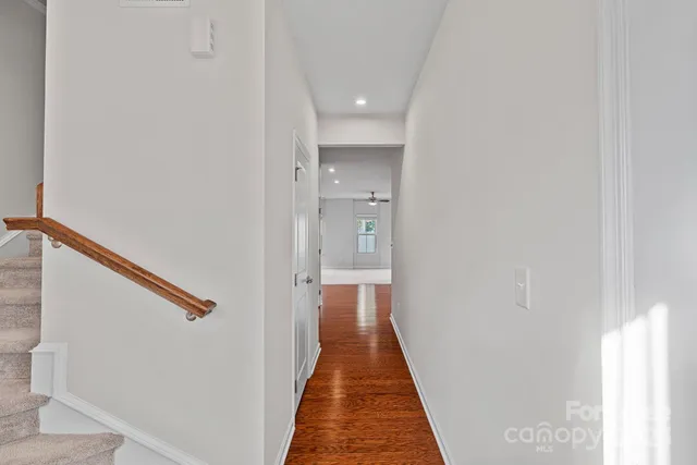 a view of a hallway with wooden floor and staircase