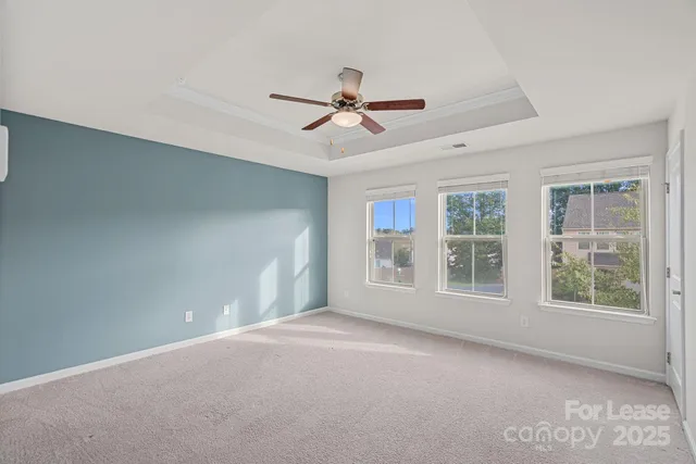 an empty room with a window and a ceiling fan