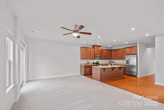 a open kitchen with kitchen island a stove a sink dishwasher and a stove with wooden floor