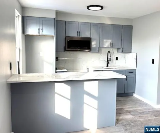 a kitchen with kitchen island a sink stainless steel appliances and cabinets