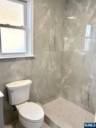 a white toilet sitting next to a window