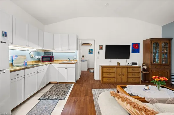 a kitchen with microwave a stove and cabinets
