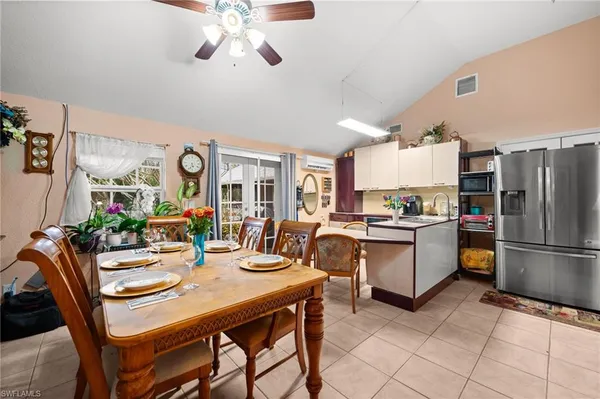 a kitchen with a dining table chairs stainless steel appliances and cabinets