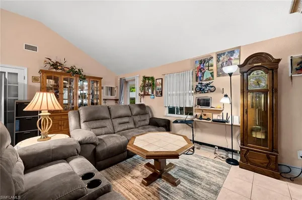 a living room with furniture a flat screen tv and a table