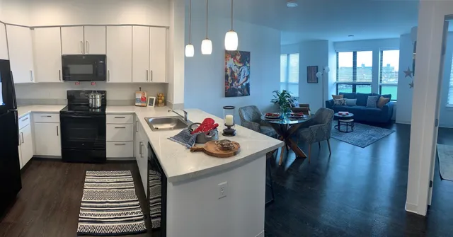 a kitchen with a sink stove and wooden floor