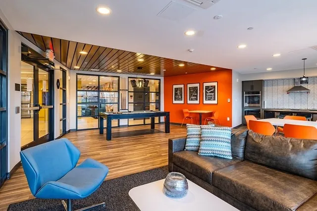 a living room with furniture kitchen view and a large window