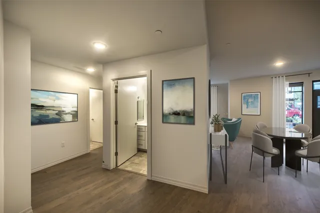a view of a hallway with wooden floor windows a chandelier and windows