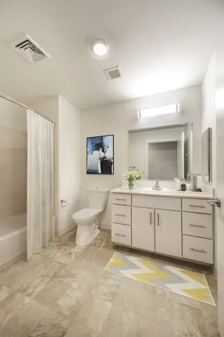 a bathroom with a granite countertop sink mirror and bathtub