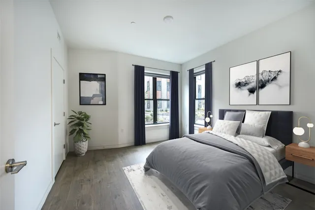 a bedroom with a large bed and a painting on the wall