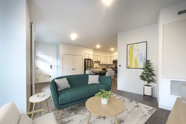 a living room with furniture and a dining table