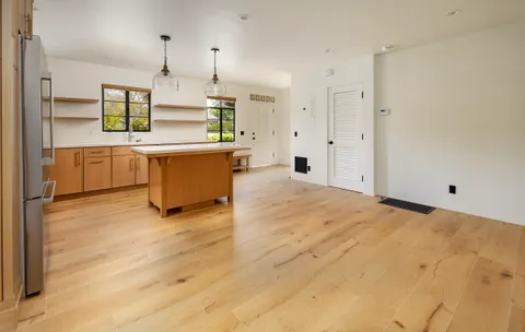 a view of a kitchen with kitchen island a sink stainless steel appliances and cabinets