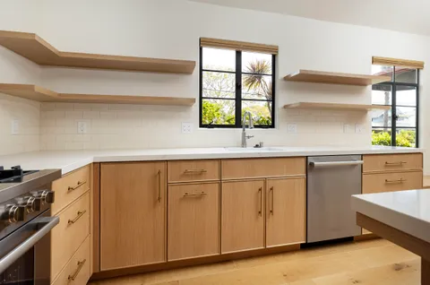 a kitchen with granite countertop cabinets stainless steel appliances and a window