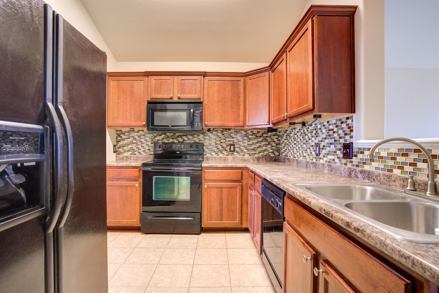 6921 95th Street Lubbock, TX 79424 - Photo 11 of 32 a kitchen with stainless steel appliances granite countertop a sink stove and refrigerator