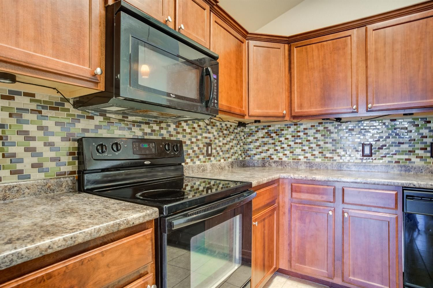 6921 95th Street Lubbock, TX 79424 - Photo 13 of 32 a kitchen with wooden cabinets and a stove top oven