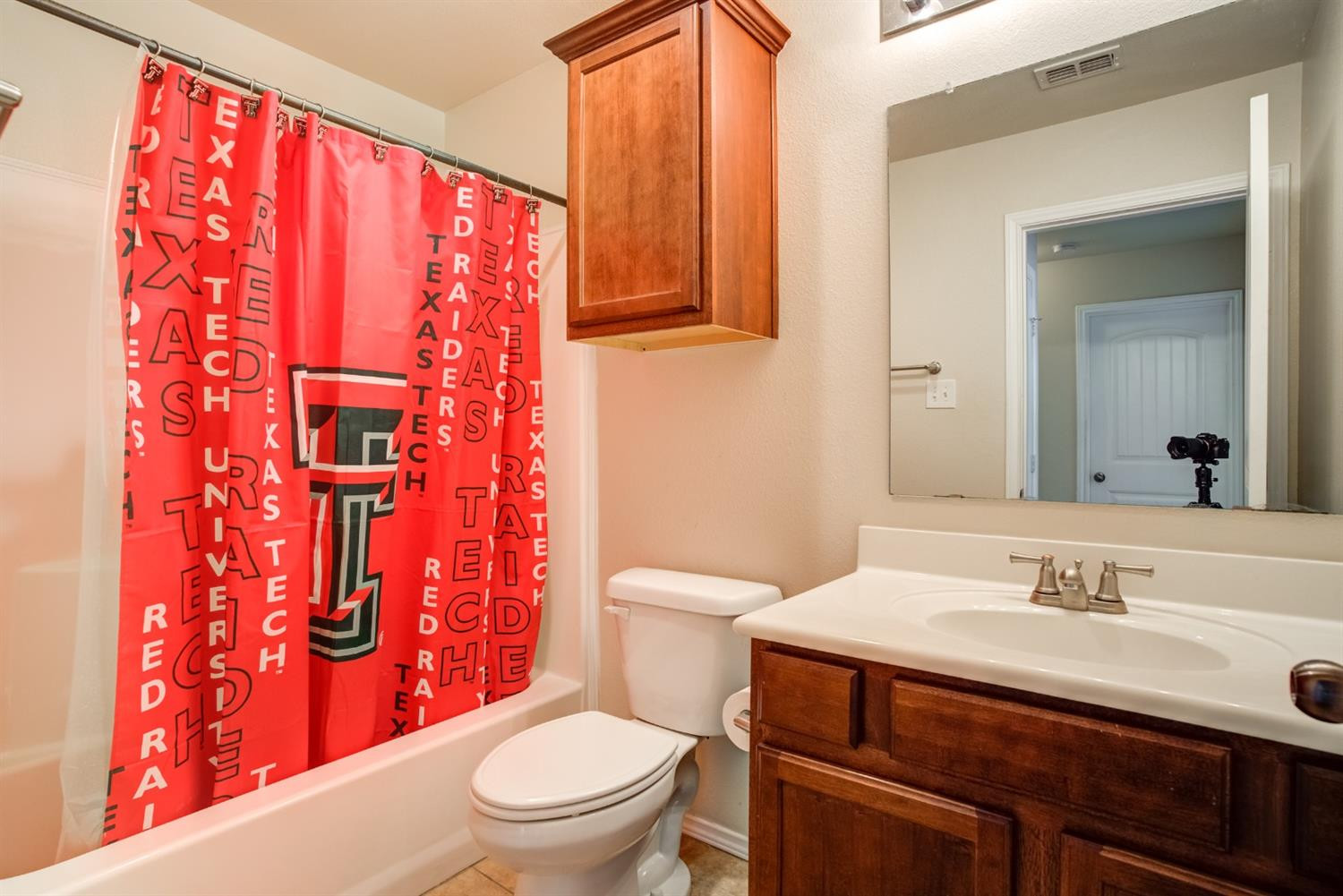 6921 95th Street Lubbock, TX 79424 - Photo 27 of 32 a bathroom with a sink a toilet and shower curtain
