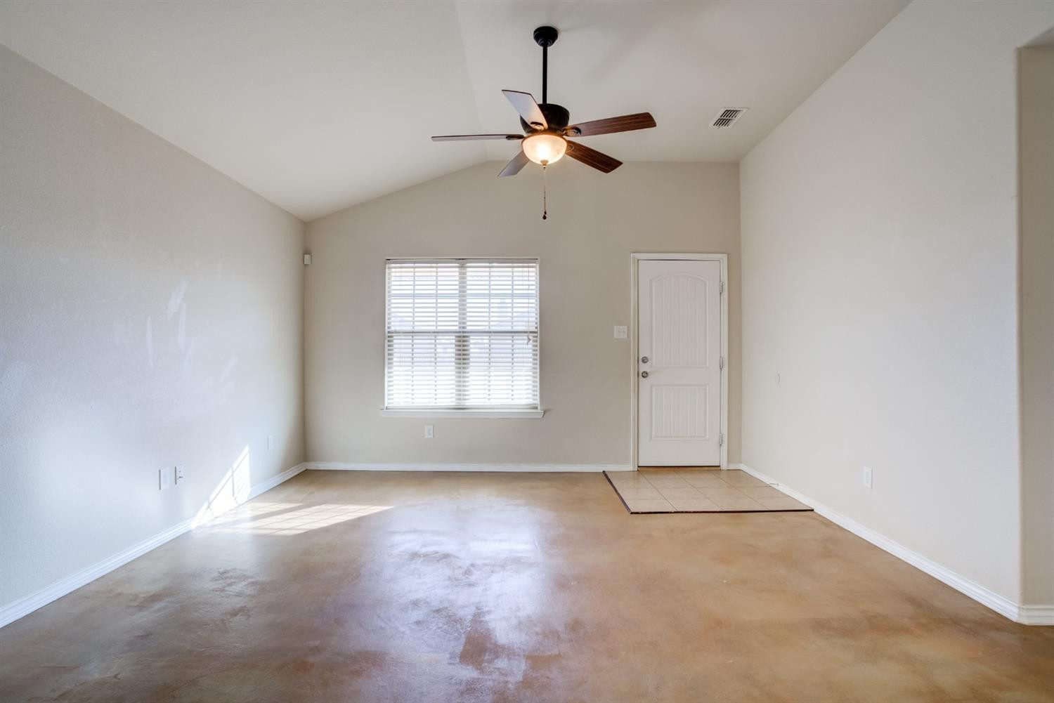 6921 95th Street Lubbock, TX 79424 - Photo 4 of 32 an empty room with windows and fan