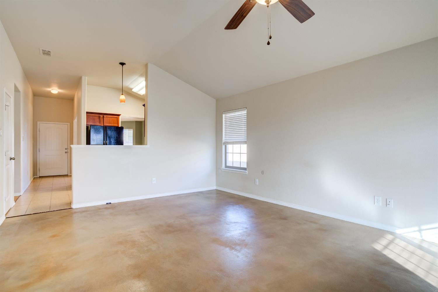 6921 95th Street Lubbock, TX 79424 - Photo 8 of 32 an empty room with chandelier fan and windows