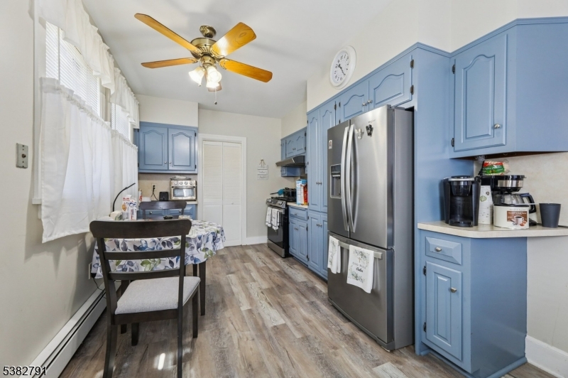 57 Greenwood Avenue Madison, NJ 07940 - Photo 11 of 30 a kitchen with stainless steel appliances granite countertop a refrigerator a stove a sink a dining table and chairs with wooden floor
