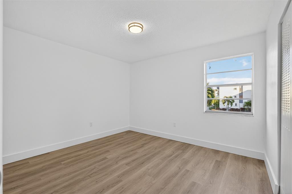 2465 Southwest 18th Avenue, Unit 3206 Miami, FL 33133 - Photo 15 of 21 a view of an empty room with wooden floor and a window