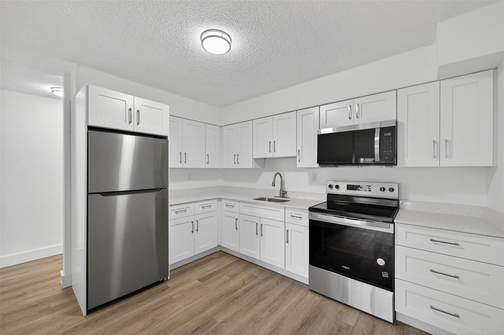 2465 Southwest 18th Avenue, Unit 3206 Miami, FL 33133 - Photo 8 of 21 a kitchen with stainless steel appliances a refrigerator stove and white cabinets