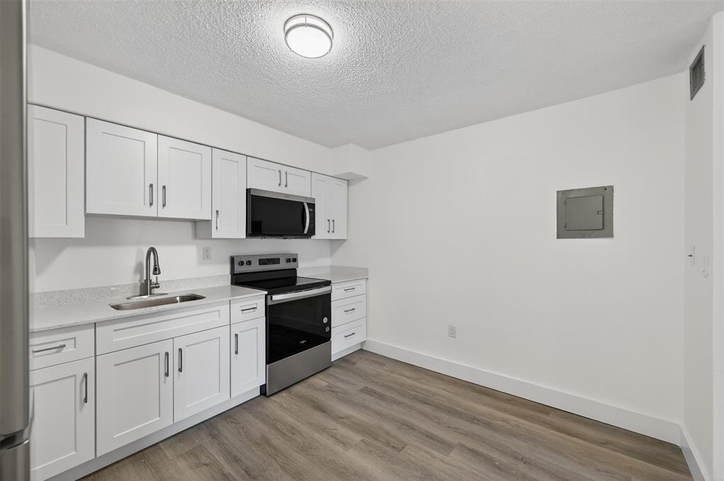 2465 Southwest 18th Avenue, Unit 3206 Miami, FL 33133 - Photo 9 of 21 a kitchen with sink a microwave and cabinets