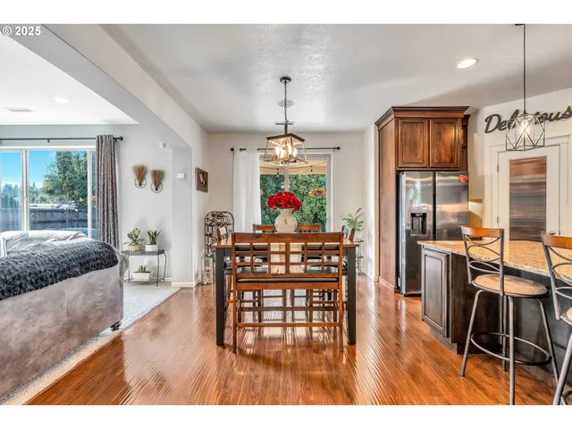 a view of a dining room and livingroom with furniture wooden floor a chandelier