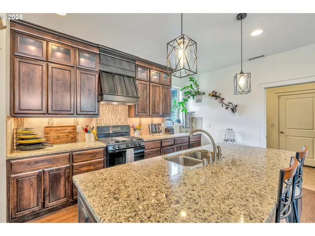 a kitchen with kitchen island granite countertop a sink stove and refrigerator