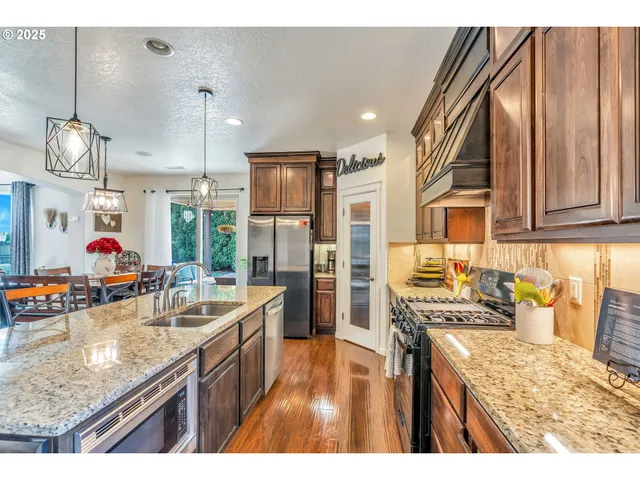 a kitchen with stainless steel appliances granite countertop a sink stove and refrigerator