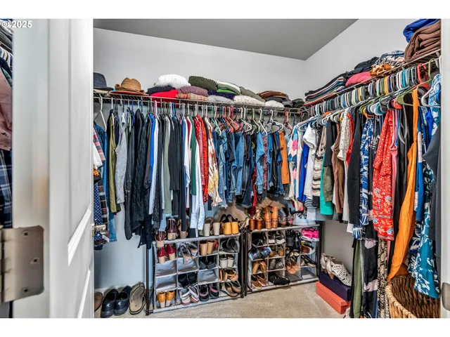 a view of walk in closet with clothes