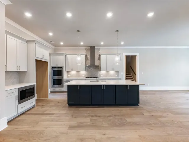 a kitchen with kitchen island granite countertop a sink stainless steel appliances and cabinets