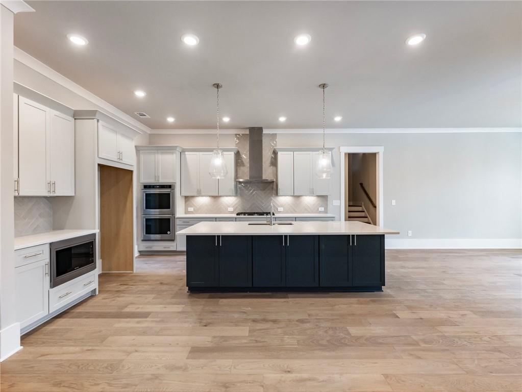 216 Ewing Way Dacula, GA 30019 - Photo 12 of 56 a large kitchen with stainless steel appliances kitchen island granite countertop a large counter top and a stove top oven