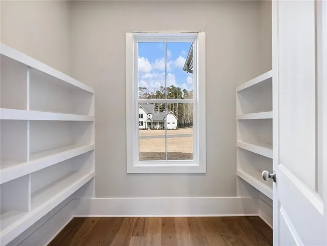 an empty room with wooden floor and windows