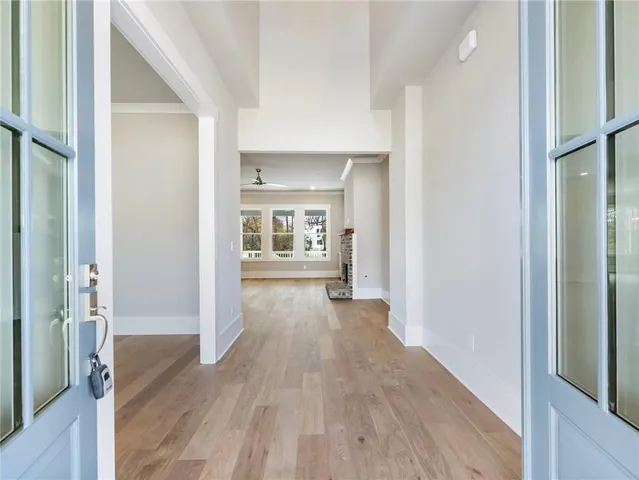 a view of a hallway with wooden floor and a living room