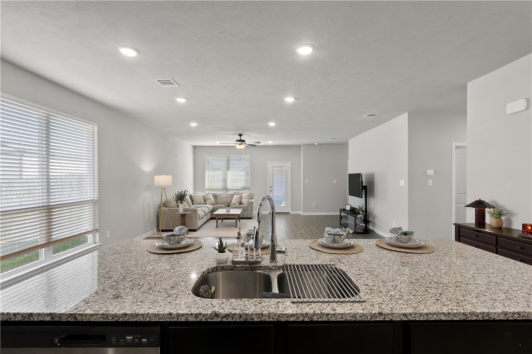 1925 Viva Road Bryan, TX 77807 - Photo 24 of 25 Kitchen featuring a kitchen island with sink, light stone counters, plenty of natural light, open floor plan, and recessed lighting
